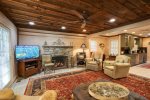 The den is perfect for watching a game or movie by the stone fireplace.